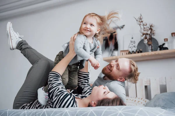 ベッドで幸せ家族母 父と子の娘笑 — ストック写真