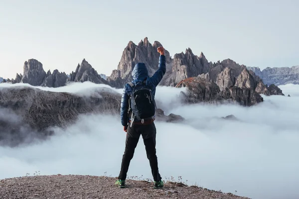 征服那座山 游客在多雾的美丽的日光群山上举起右手 — 图库照片