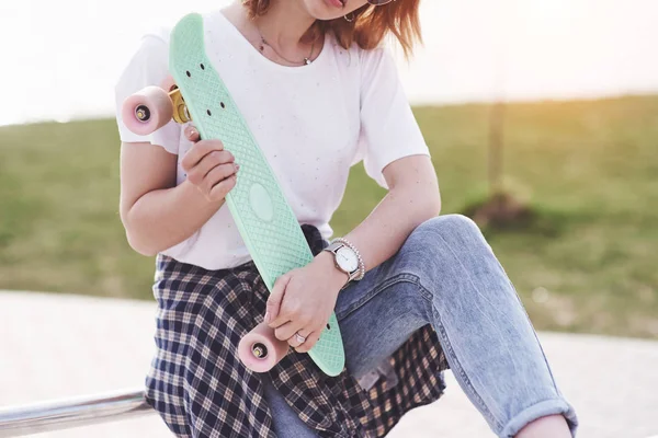 スケートパークのランプに座って美しい10代の女性スケーター 夏の都市活動の概念 — ストック写真