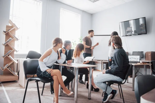 Group of young business people working and communicating together in creative office.