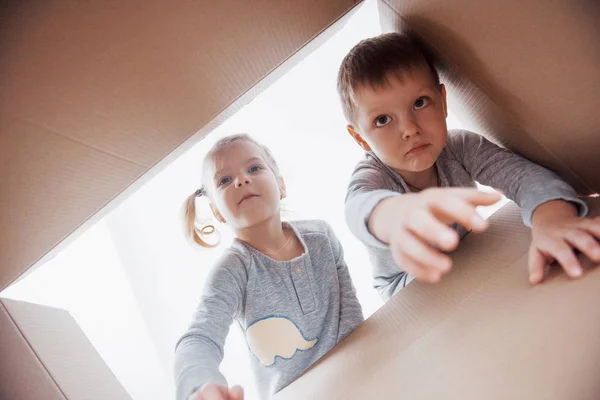 Dvě Malé Děti Chlapec Dívka Otevírá Lepenkovou Krabici Dívá Dovnitř — Stock fotografie