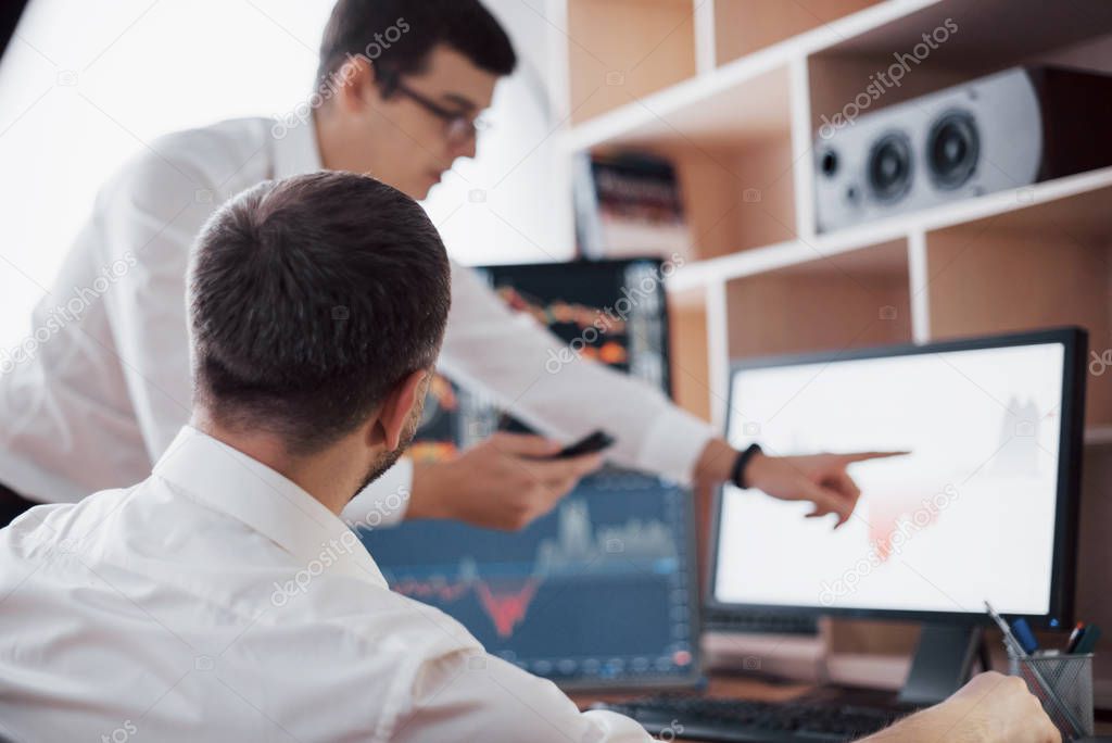 Analyzing data. Close-up of young business team working together in creative office while young woman pointing on the data presented in the chart with pen.