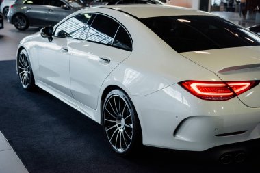 Aracın arkasında. Yeni beyaz lüks modern araba otomobil fuarında kapalı duruyor..