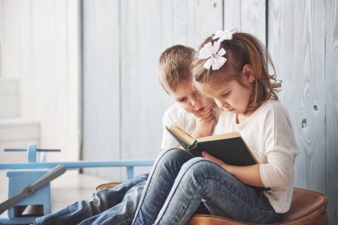 Büyük seyahate hazırız. Küçük mutlu kız ve çocuk büyük bir evrak çantası taşıyan ilginç bir kitap okuyor. Özgürlük ve hayal gücü kavramı.