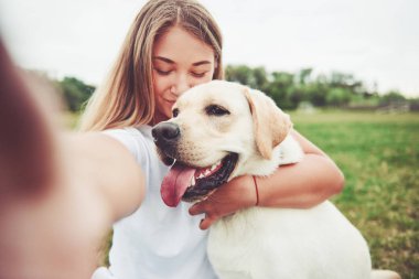 Çekici genç kadın labrador açık havada. Kadın ile köpek labrador geri almak yeşil çimenlerin üzerinde.