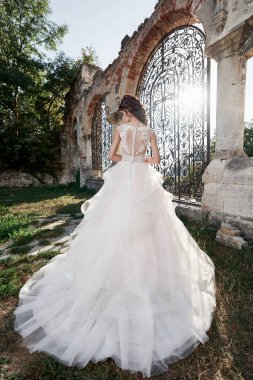 Gelinlik içinde güzel bir gelin, düğün günü eski şatonun yakınlarında çekiliyor.