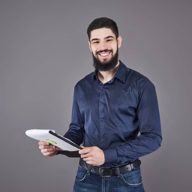 Mavi gömlekli genç ve çekici bir iş adamı. Panoya yazı yazıyor..
