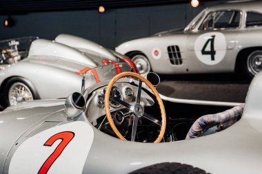 Yan, gri retro spor coupe cabriolet iç görünümü: ahşap direksiyon, gösterge paneli, ayna, sol kapıda 2 numara boyalı, arka planda çok sesli alaşımlı diskler ve klasik araba