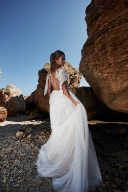 Kız lüks gelinlik deniz kıyısında poz. Gelin bir buzlu