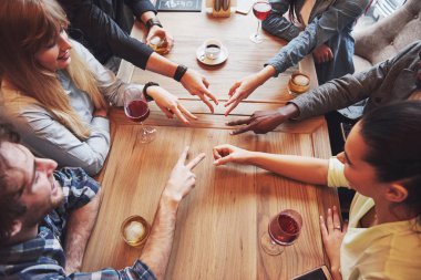 Genç insanların el ele tutuşmalarını yakından izleyin. Birliktelik ve takım çalışması gösteren parmaklarıyla Yıldız Şekli Yapan Arkadaşlar