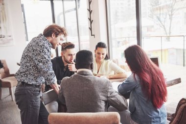 Bir grup sıradan giyimli iş adamı fikirleri tartışıyor. Yaratıcı profesyoneller, yeni başarılı girişim projesinin önemli konularını tartışmak üzere bir araya geldiler. Takım çalışması Beyin Fırtınası konsepti.