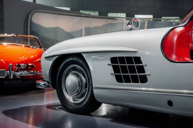 Kırmızı arabanın arkasında, beyaz aracın ön tarafında..