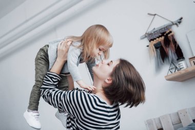 Sevgi dolu bir aile. Anne ve kızı oynuyorlar ve sarılıyorlar..