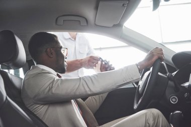 Genç siyahi iş adamı test sürüşü yapıyor. Zengin Afro-Amerikan erkeği.