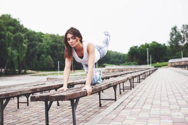 Güzel bir esmer sporcu dışarıda egzersiz yapıyor..