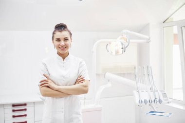 Tıbbi geçmişinde aletleri olan mutlu genç bir dişçi. Stomatoloji ve sağlık konsepti.