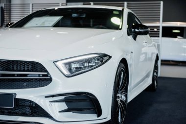 Yeni beyaz lüks modern araba otomobil fuarında kapalı duruyor. Ön görünüm.