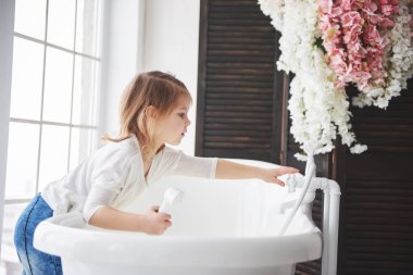 Kıvırcık saçlı komik küçük kız. Banyo yapmaya hazır ol. Geniş ışıklı banyo. Sağlıklı ve temiz vücut kavramı. Çocukluğundan beri kendine dikkat et..
