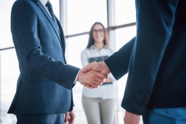 Ofisteki bir toplantıda el sıkışan iki kendine güvenen iş adamı, başarı, anlaşma, selamlama ve ortaklık kavramı.