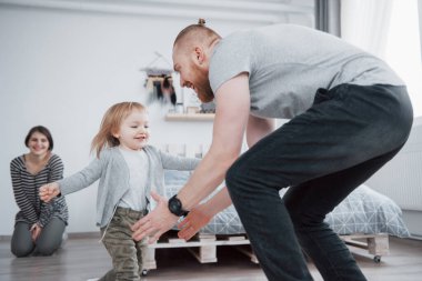 Mutlu aile evde eğleniyor. Anne, baba ve küçük kız pelüş oyuncaklarla birlikte olmanın tadını çıkarıyorlar..