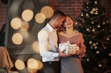 Ağaçtaki çelenkler. Kadın için Noel hediyesi. Klasik takım elbiseli beyefendi hediyesini karısına verir..