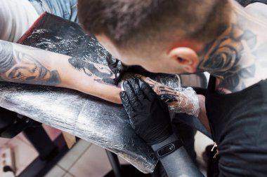 Dövme makinesini kapat. Siyah steril eldivenler ustası. Kuaförde resim yapıyor..