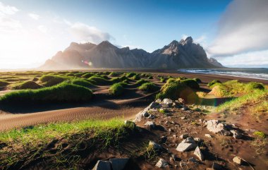 Fantastic west of the mountains and volcanic lava sand dunes on the beach Stokksness, Iceland. Colorful summer morning Iceland, Europe.