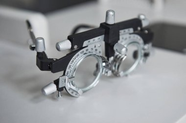 Beyaz masada duran phoropter 'in detaylı yakın plan fotoğrafı.