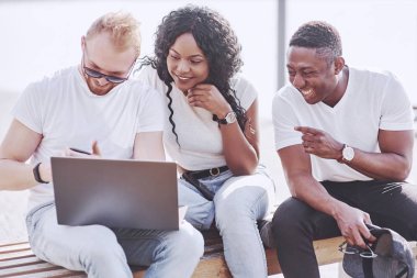 Sokakta dizüstü bilgisayar kullanan çok uluslu güzel arkadaşlar. Gençlik yaşam tarzı konsepti.