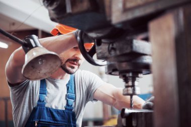 Başlık takmış deneyimli bir operatör. Metal endüstrisi konsepti profesyonel mühendis metal işçisi imalat atölyesinde Cnc değirmen makine merkezi işletiyor.
