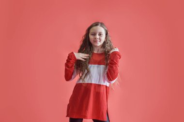 Genç şehir kadını kırmızı arka planda dans ediyor, modern ince hip-hop stili genç kız.