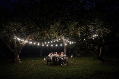 Birlikte mutluyuz. Akşam vakti. Arkadaşlar muhteşem açık havada yemek yer..