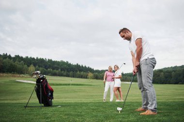 Golf sahasındaki bir grup şık arkadaş yeni bir oyun öğreniyor..