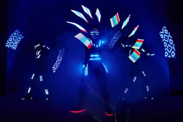 Laser show performance, dancers in led suits with LED lamp, very beautiful night club performance, party.