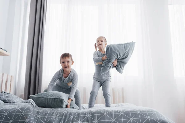 애들은 부모님 침대에서 아이들은 침실에서 일어난다 일치하는 잠옷을 아기와 아기를 — 스톡 사진