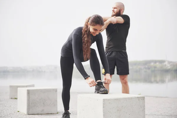 Fitnesspaar Dat Zich Buiten Het Park Bij Het Water Uitstrekt — Stockfoto