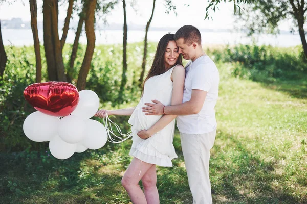 幸せと若い妊娠中のカップルが自然の中で抱擁 ロマンチックな瞬間 — ストック写真