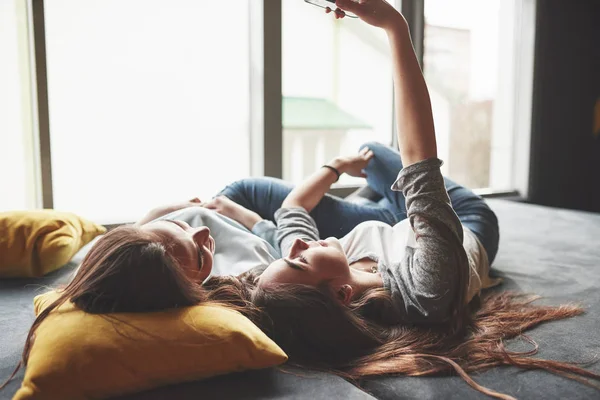 Dos Hermanas Gemelas Sonrientes Lindas Sosteniendo Teléfono Inteligente Haciendo Selfie —  Fotos de Stock