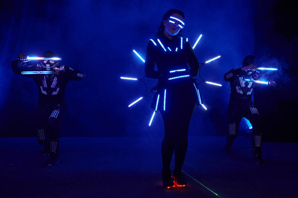Laser show performance, dancers in led suits with LED lamp, very beautiful night club performance, party.