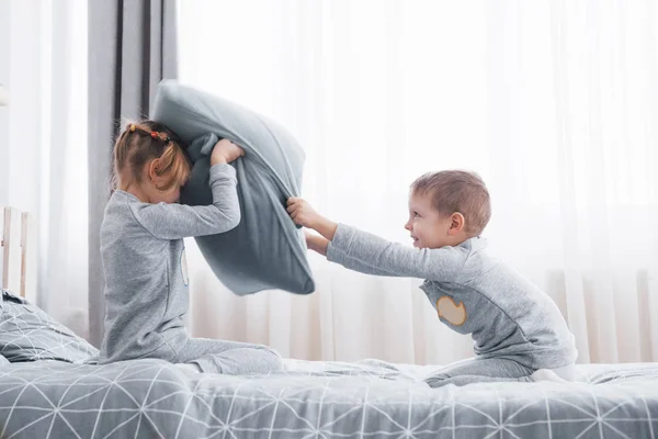 소년과 소녀는 침실에서 침대에 싸움을 벌였다 어린이 베개를 그들은 종류의 — 스톡 사진