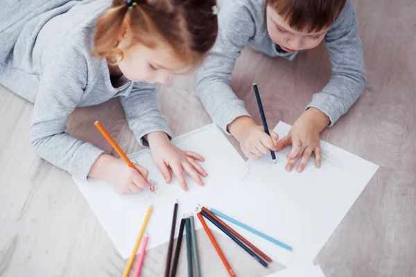 Çocuklar Pijamalarıyla Yere Yatar Kalemle Çizerler Kalemlerle Resim Yapan Şirin — Stok fotoğraf