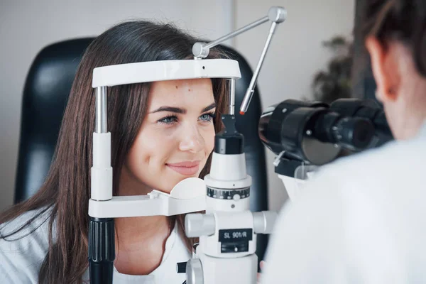Optometrist genç ve güzel bir kadının görüşünü kontrol ediyor..