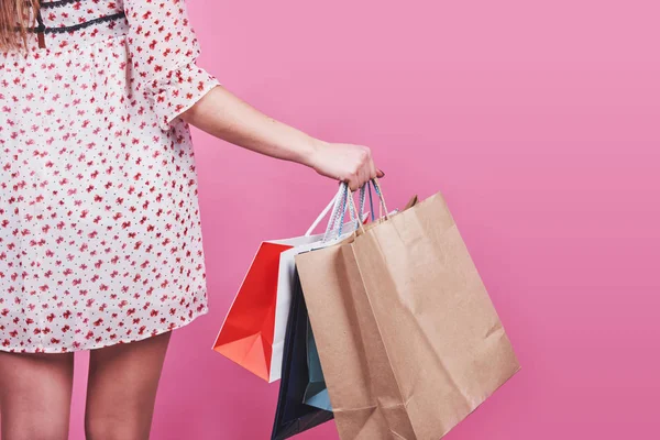 Close Van Vrouwelijke Hand Houden Kleurrijke Boodschappentassen Roze Achtergrond — Stockfoto