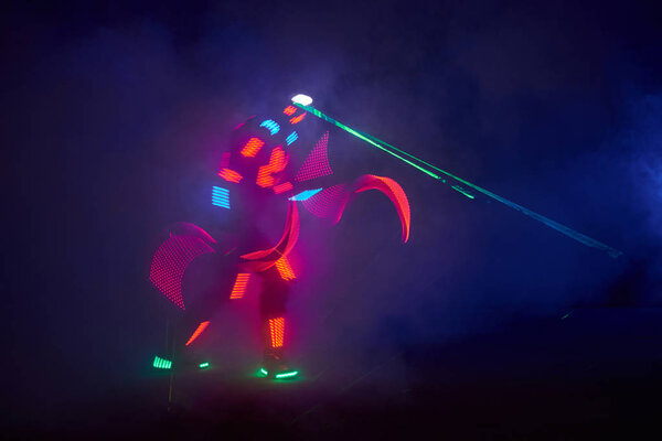 Laser show performance, dancers in led suits with LED lamp, very beautiful night club performance, party.