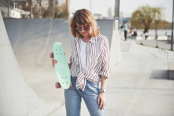 スケートボードを持つスタイリッシュな美しい若い女性 美しい夏の晴れた日に — ストック写真
