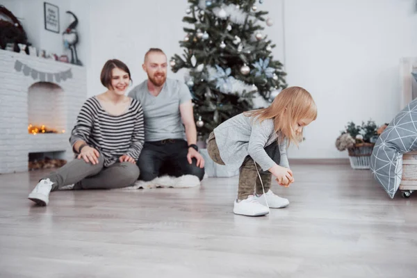 メリークリスマスとハッピーニューイヤー 美しいお母さん お父さんと娘はクリスマスプレゼントの近くに座っている間にラップトップと笑顔を使用しています — ストック写真