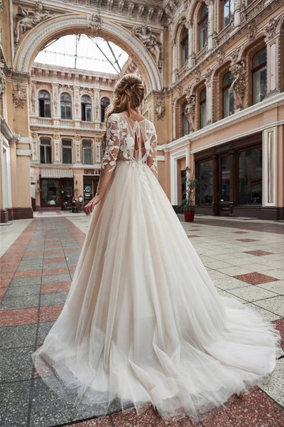 Beautiful, elegant bride with a perfect wedding dress, poses around beautiful architecture