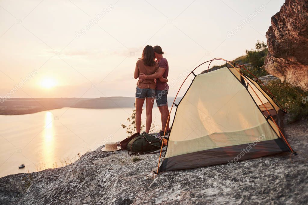 Photo of happy near tent with a view of lake during hiking trip. Travel Lifestyle adventure vacations concept.