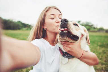 Çekici genç kadın labrador açık havada. Kadın ile köpek labrador geri almak yeşil çimenlerin üzerinde.