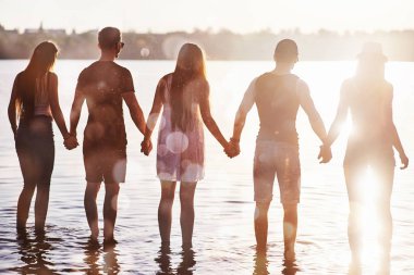 Mutlu arkadaşlar sahilde eğlenir - yaz tatilinde genç insanlar.